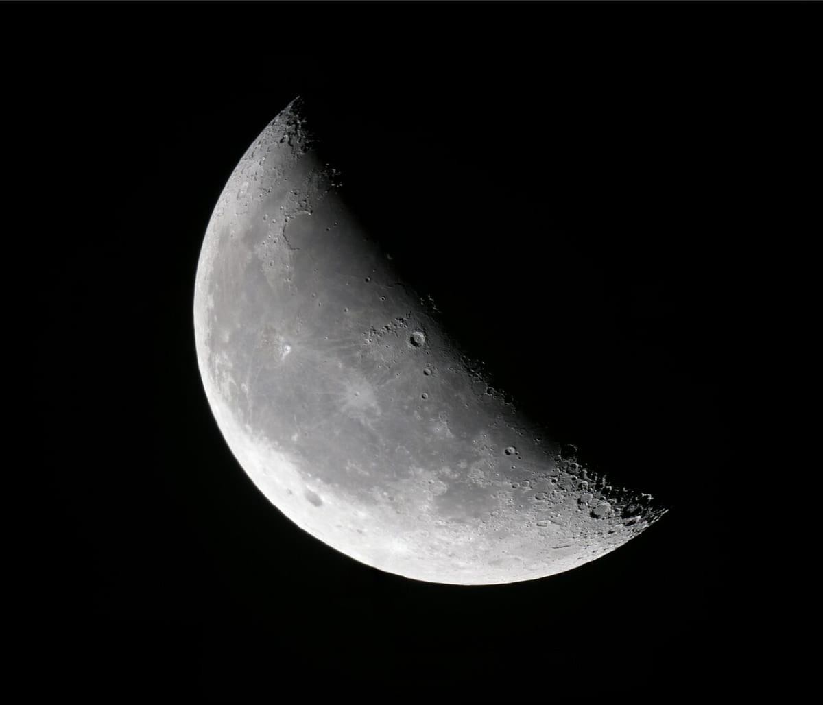 Der zunehmende Mond als schmale Sichel, entlang der Schattengrenze sind Krater scharf gezeichnet