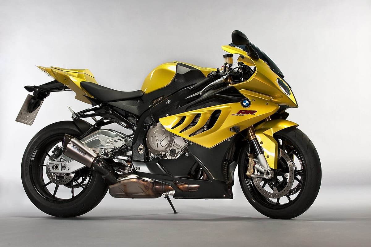 Ein gelb-schwarzes Motorrad im Studio, gleichmäßig vor hellem Verlaufshintergrund ausgeleuchtet